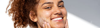 Skincare - woman rubbing cream on face.